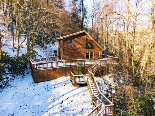 a log cabin in the woods in the snow at River Front Resort in Elkins