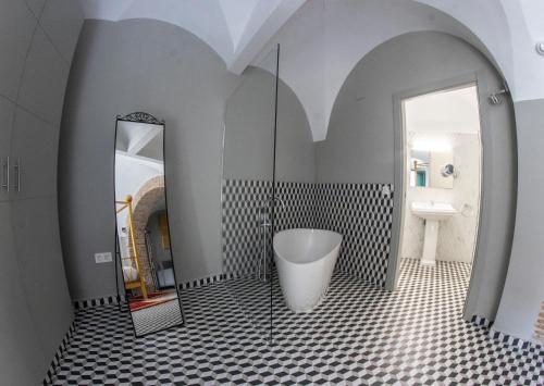 a bathroom with a tub and a mirror at Hotel Rural La Casa de Carlota in Montánchez