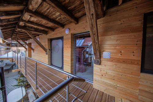 Un balcón de una casa de madera con puerta en Le Domaine du Verger, Chambres et SPA prive, en Osenbach