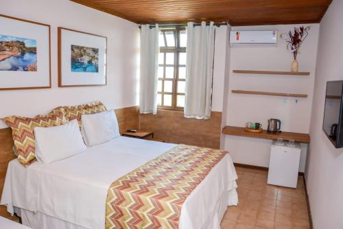 a bedroom with a white bed and a window at Casarão Alpina in Mucugê