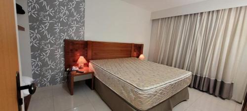 a small bedroom with a bed and a nightstand with a bed sidx sidx sidx at Rio Quente Luppi Hotel in Rio Quente