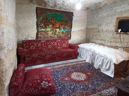 a living room with a red couch and a rug at CAVE HOUSE(KIR EVİ) in Urgup