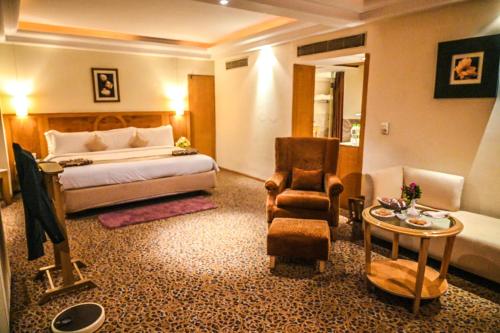 a hotel room with a bed and a chair at Katriya Hotel and Tower in Hyderabad