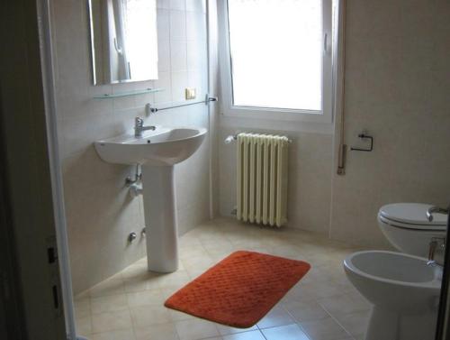 a bathroom with a sink and a toilet and a window at Borno B&B in Borno
