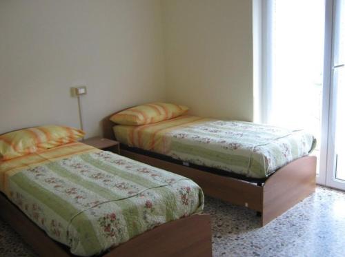 ボルノにあるBorno B&Bのベッド2台と窓が備わる客室です。