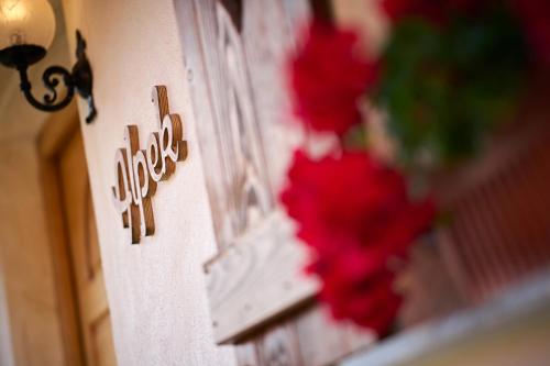 a sign on the side of a building with red flowers at Farm Stay "Alpine Dreams" in Solčava