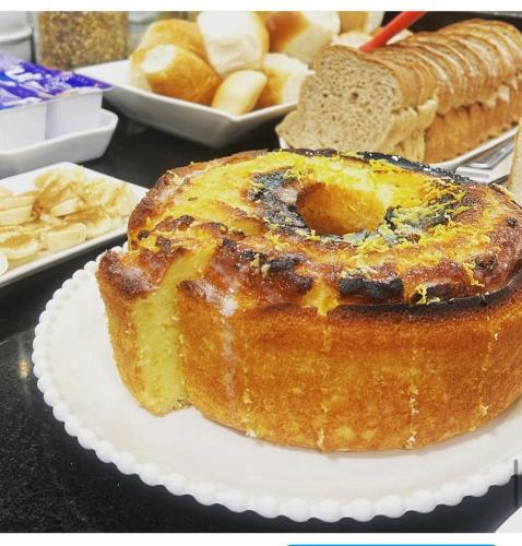 a cake on a plate on a table with bread at Hotel Germânia Nova Veneza in Nova Veneza
