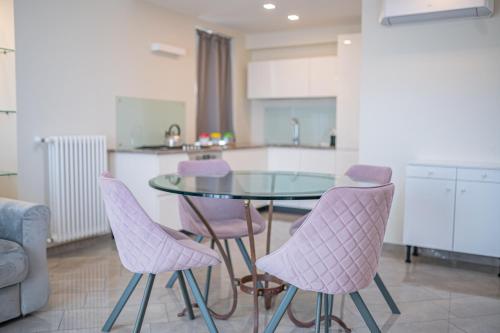 a kitchen with a glass table and purple chairs at Casa Umberto I , Taormina Centro in Taormina