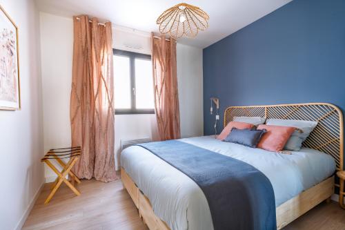 een slaapkamer met een bed met blauwe muren en een raam bij La Perle Villa neuve, proche gare, comédie, et tramway in Montpellier