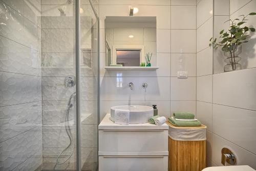 a white bathroom with a sink and a shower at Mare‘s Place - Premium Seaview Apartment in Slatine