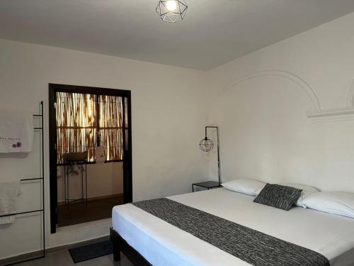 a white bedroom with a bed and a window at Casa Malva Sweet Stay in Guanajuato