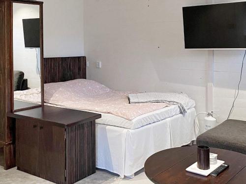 1 dormitorio con cama con espejo y mesa en Holiday home UDDEVALLA XXXI en Uddevalla