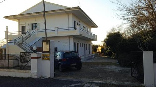 a car parked in front of a house at Villa Kaloudis Rooms in Agios Georgios