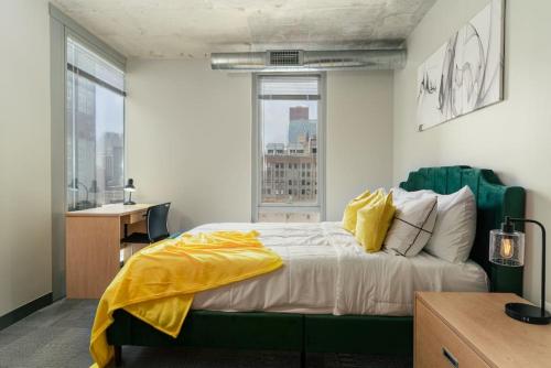 a bedroom with a bed with a yellow blanket on it at Affordable 2-Bedroom on Wabash in Chicago