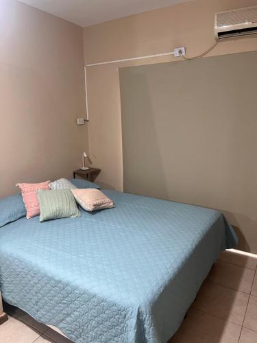 um quarto com uma cama azul com duas almofadas em Mono ambiente a pasos de la COSTANERA Tercer piso escalera em Posadas