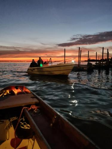 two people sitting on a boat in the water at Ca' Nova - Burano in Burano