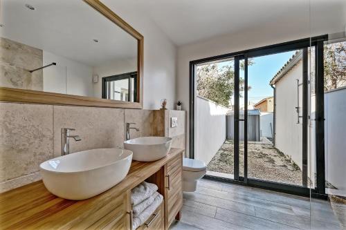 baño con 2 lavabos y ventana grande en La Tavelloise - Villa moderne avec piscine, en Tavel