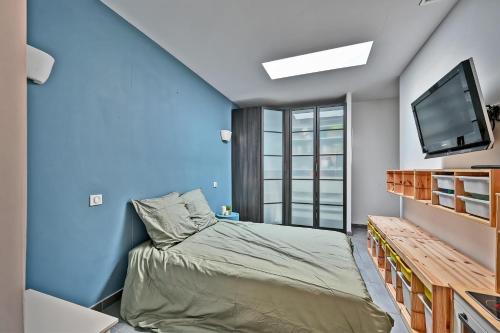 1 dormitorio pequeño con 1 cama y TV en La Tavelloise - Villa moderne avec piscine, en Tavel