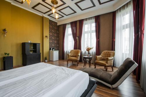 オラデアにあるApartamente La Teatru Orientの大きなベッドと椅子2脚のある寝室