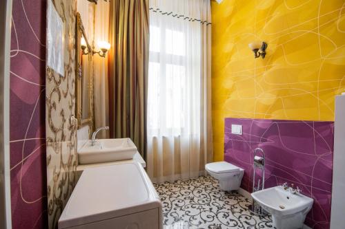 オラデアにあるApartamente La Teatru Orientの紫と黄色のバスルーム(洗面台、トイレ付)