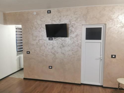 a room with a wall with a television on it at Casa de la Nuc in Târgu Jiu