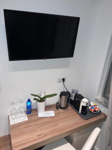 a television hanging on a wall above a wooden table at Villa Chiara Taormina in Taormina