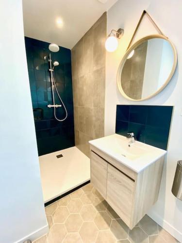 une salle de bain avec un lavabo et une douche avec un miroir dans l'établissement Amateru - SILS, à Caen
