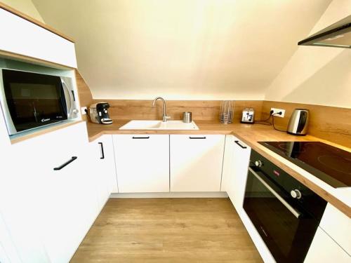 a kitchen with white cabinets and a sink at Amateru - SILS in Caen
