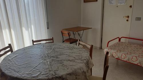 een tafel en stoelen in een kamer met een tafel en een bed bij Apolloni di Loano appartamento privato - Codici Citra visibili su STRUTTURA in Loano