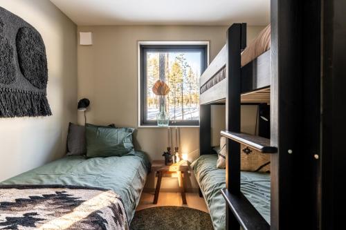 a bedroom with two bunk beds and a window at Nybyggda parhus i Idre in Idre Fjäll