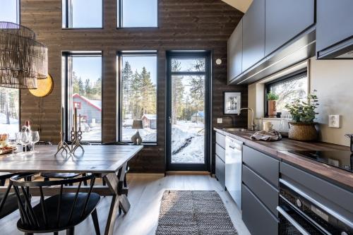 a kitchen with a table and chairs and a large window at Nybyggda parhus i Idre in Idre Fjäll