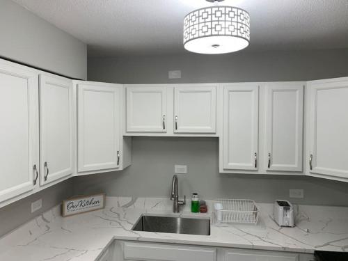 a kitchen with white cabinets and a sink at Affordable One Bedroom Rockford in Rockford