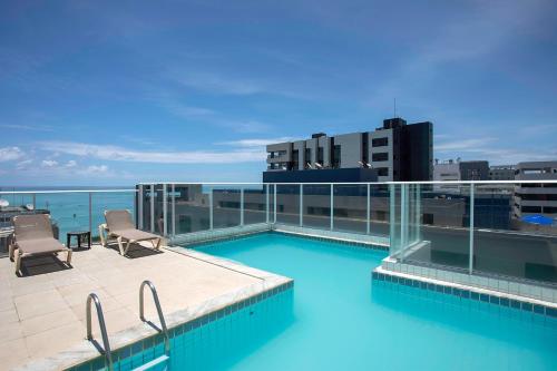 a swimming pool on the roof of a building at Slim Pajuçara by Tropicalis in Maceió