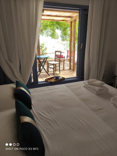 a bedroom with a bed with a view of a patio at Philoxenia, maison et table d'hôtes in La Saline les Bains