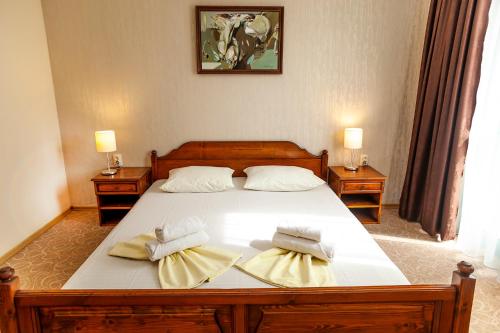 a bedroom with a large bed with two towels at Ravda Bay Guest House in Ravda