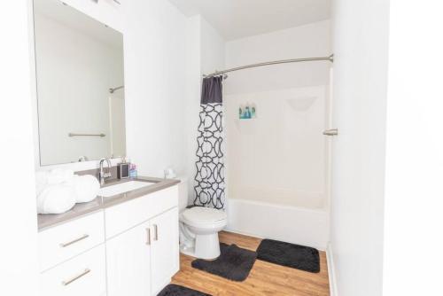 a white bathroom with a toilet and a shower at Affordable 1BD, Comfy Queen Beds, with GYM in Indianapolis