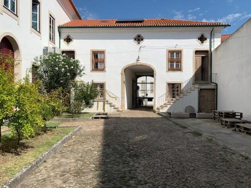 un gran edificio blanco con un arco delante de él en Ilha 12 Suites en Coimbra
