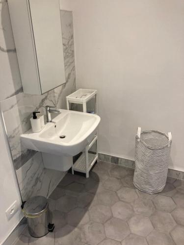 a white bathroom with a sink and a mirror at Affittacamere Archivolto del Teatro in Albenga