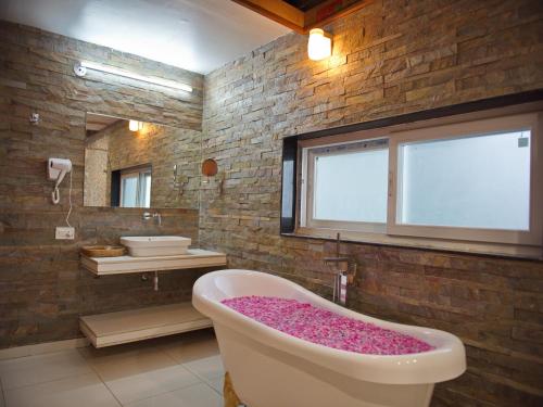 a bathroom with a large bath tub with a window at Wild Rose Resort and Spa in Pushkar