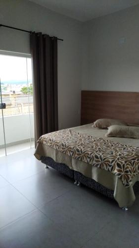 a bedroom with a bed and a large window at Hotel Central in Boa Esperança