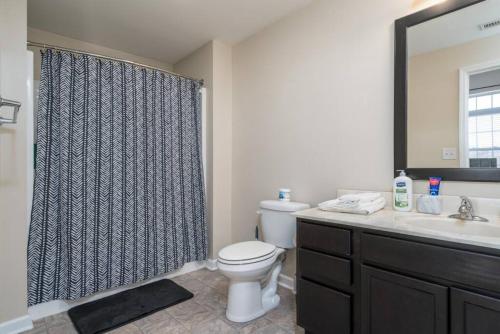 uma casa de banho com um WC, um lavatório e um chuveiro em Downtown INDY Private Bedroom - Shared em Indianápolis