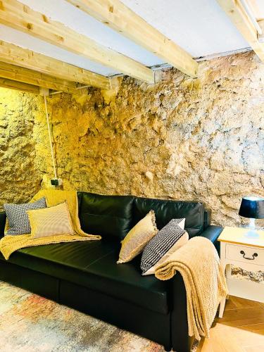 Sofá verde en una habitación con pared de piedra en La Ruta - La Cueva, en Confrides