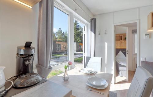 ein Esszimmer mit einem Tisch und einem großen Fenster in der Unterkunft Tiny Haus 46 Am Brombachsee in Pleinfeld