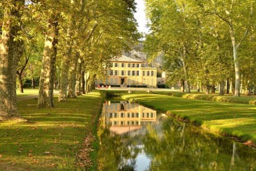un canal en un parque con una casa y árboles en Maison + piscine à 10 min d'Aix en Pce, en Meyreuil