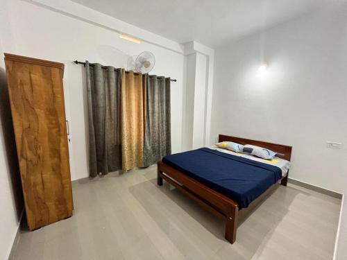 Schlafzimmer mit einem Bett und einer Holztür in der Unterkunft Wayanad Biriyomz Residency, Kalpatta, Low Cost Rooms and Deluxe Apartment in Kalpatta