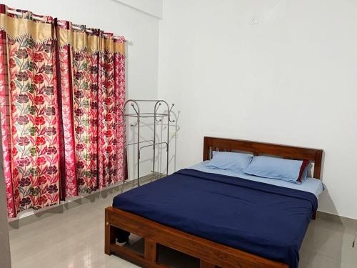 a bedroom with a bed and two curtains at Wayanad Biriyomz Residency, Kalpatta, Low Cost Rooms and Deluxe Apartment in Kalpetta