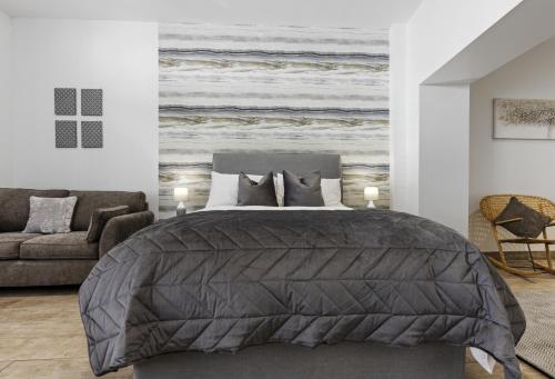a bedroom with a bed and a couch at Stayover Suites in Ballymena