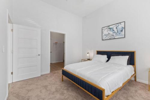 Luxurious 1-Bedroom Fishers في فِشرز: غرفة نوم بسرير كبير مع شراشف بيضاء
