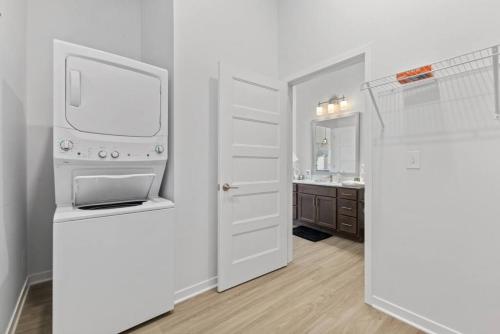 Luxurious 1-Bedroom Fishers في فِشرز: غرفة بيضاء مع تلفزيون ومغسلة