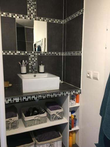 une salle de bain avec un lavabo blanc et un miroir dans l'établissement LA CALMERAIE, à Villeneuve-Loubet